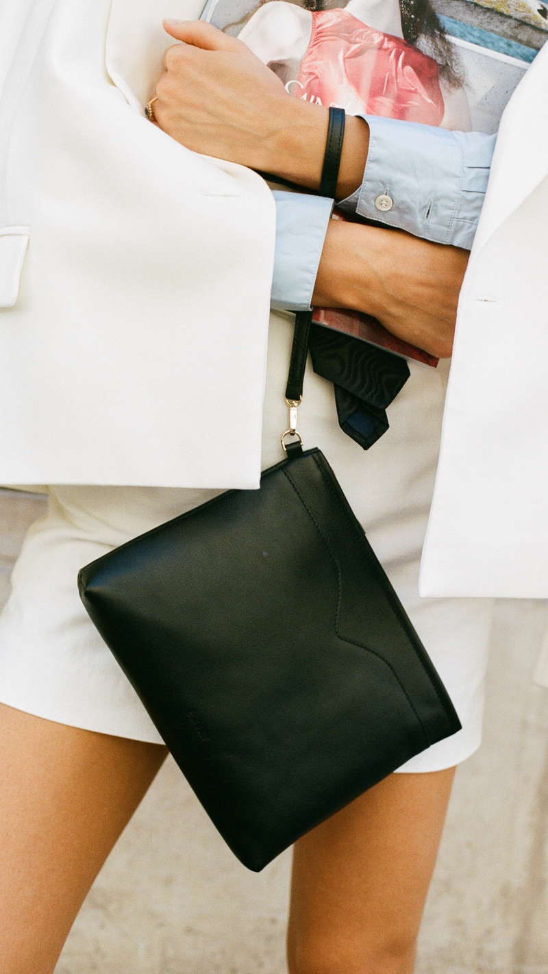Ava premium leather pouch in black by Esnner, minimalist clutch with wrist strap for evening or daily use.